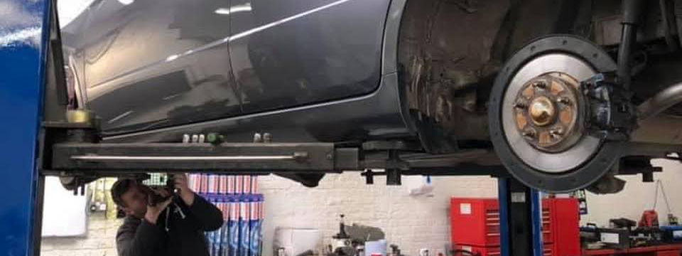 Mechanic under a vehicle doing repairs - Car Repairs Torquay
